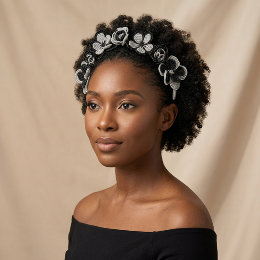 Model wearing the Midnight Bloom Beaded Floral Necklace — a headband of black and silver beaded floral rose appliques, against a warm beige draped backdrop.