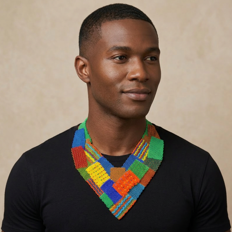 Model in a black V-neck wearing the Beaded Collar Necklace in a multicolour patchwork of green, blue, red, yellow and orange beaded panels, against a tan background.