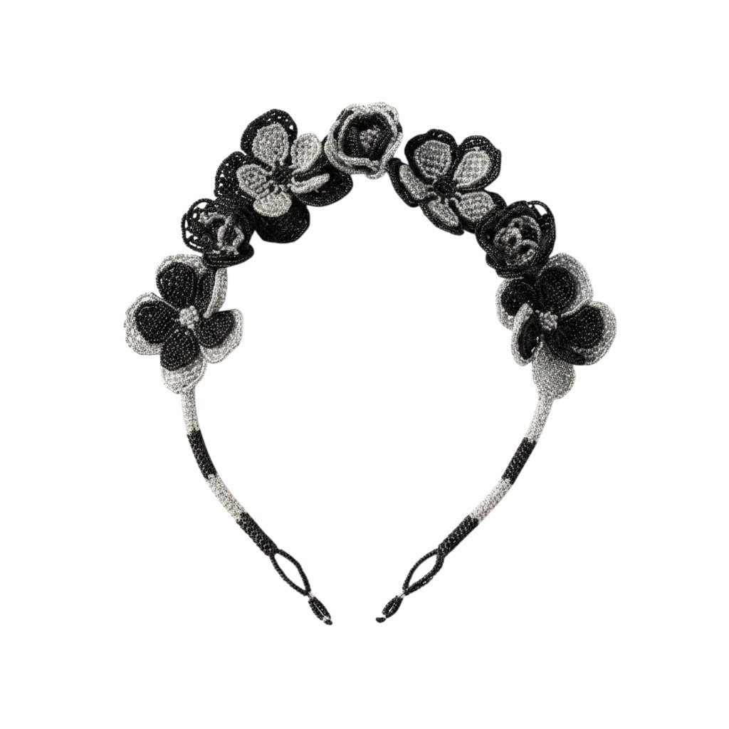 Flat lay product shot of the Midnight Bloom Beaded Floral Necklace — a beaded headband with black and silver rose and flower appliques, on a plain white background.