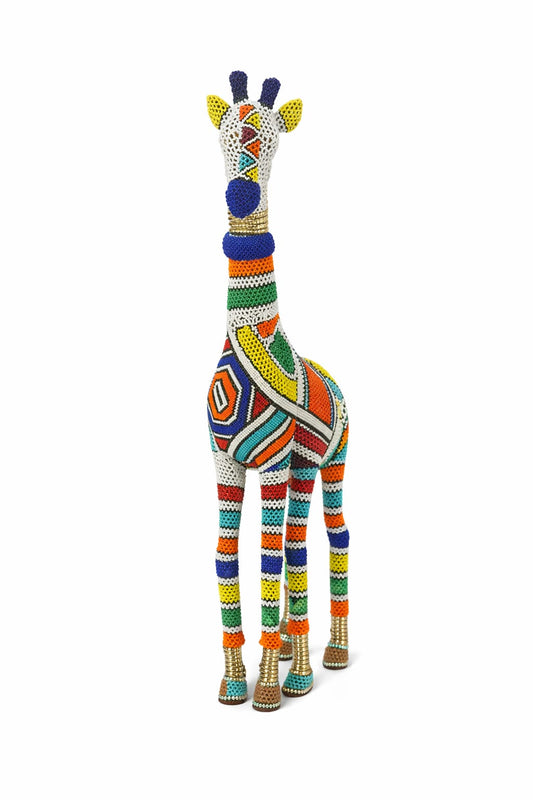 Product shot of the Ndebele Beaded Giraffe Sculpture on a white background — a tall giraffe figurine covered in colourful geometric Ndebele beadwork in white, orange, blue, green, yellow and red.