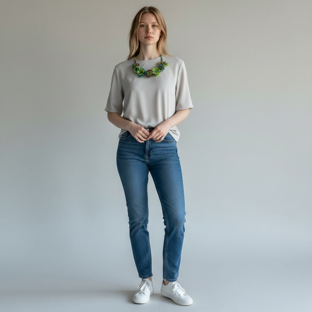 A model wearing a Tinkers handcrafted beaded floral collar necklace with lime, teal, and bronze rose blooms.