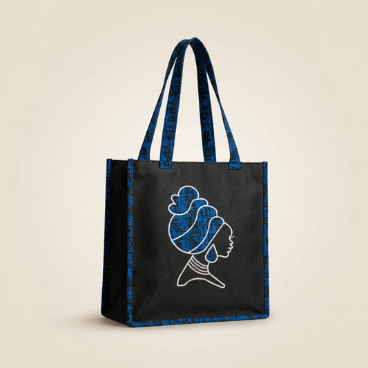 Tinkers black fabric tote bag featuring a white embroidered silhouette of a woman with a headwrap and blue patterned straps