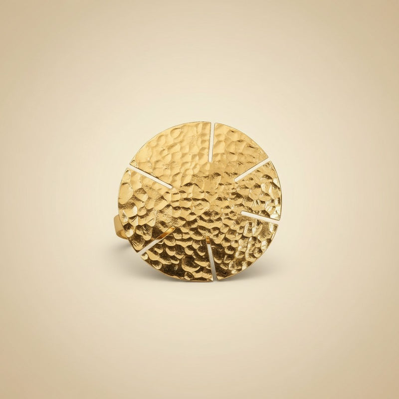 Tinkers oversized hammered brass statement ring featuring a large circular disc with a sun-ray segmented pattern.