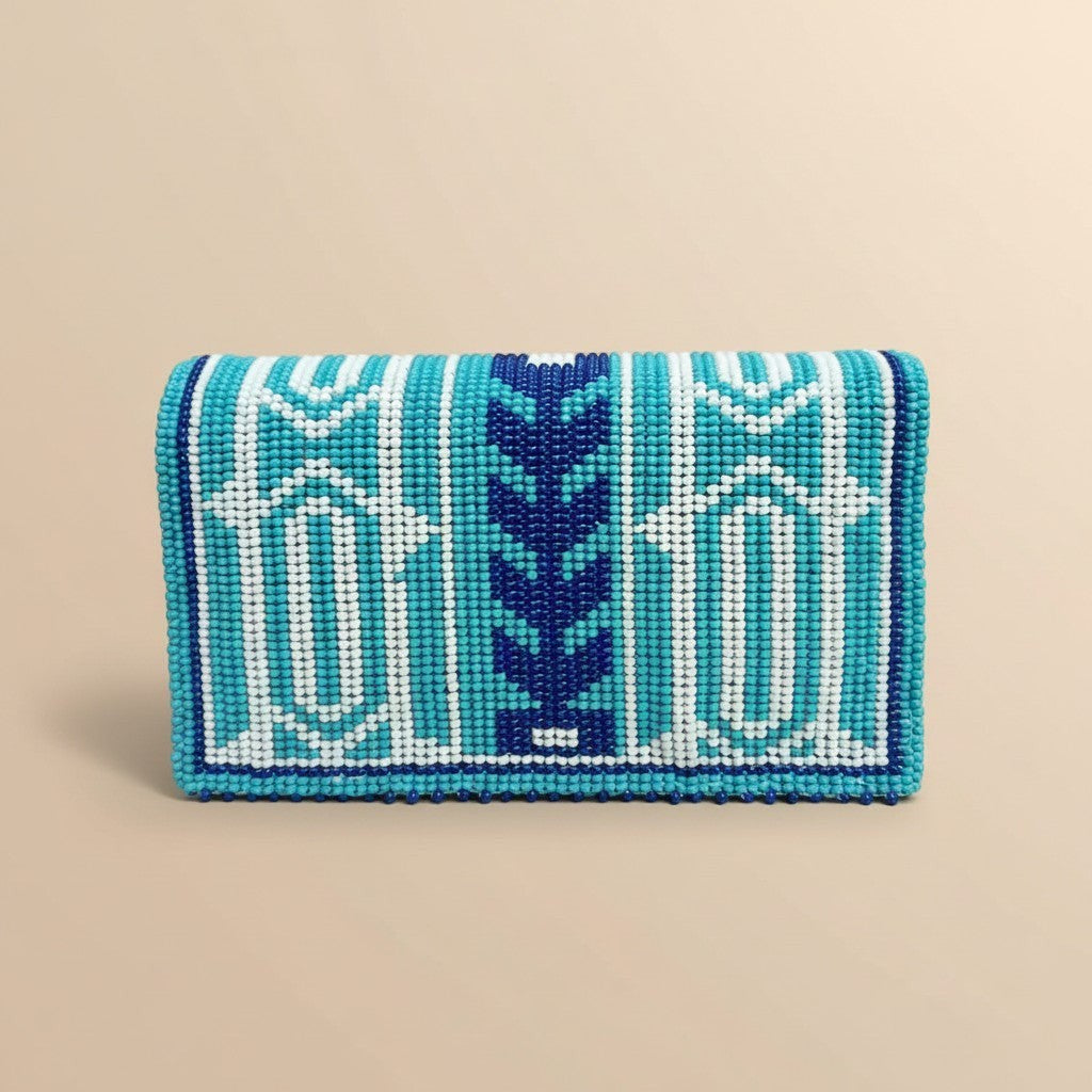 Tinkers turquoise, navy, and white geometric beaded clutch with a central zigzag motif and arched lid design.